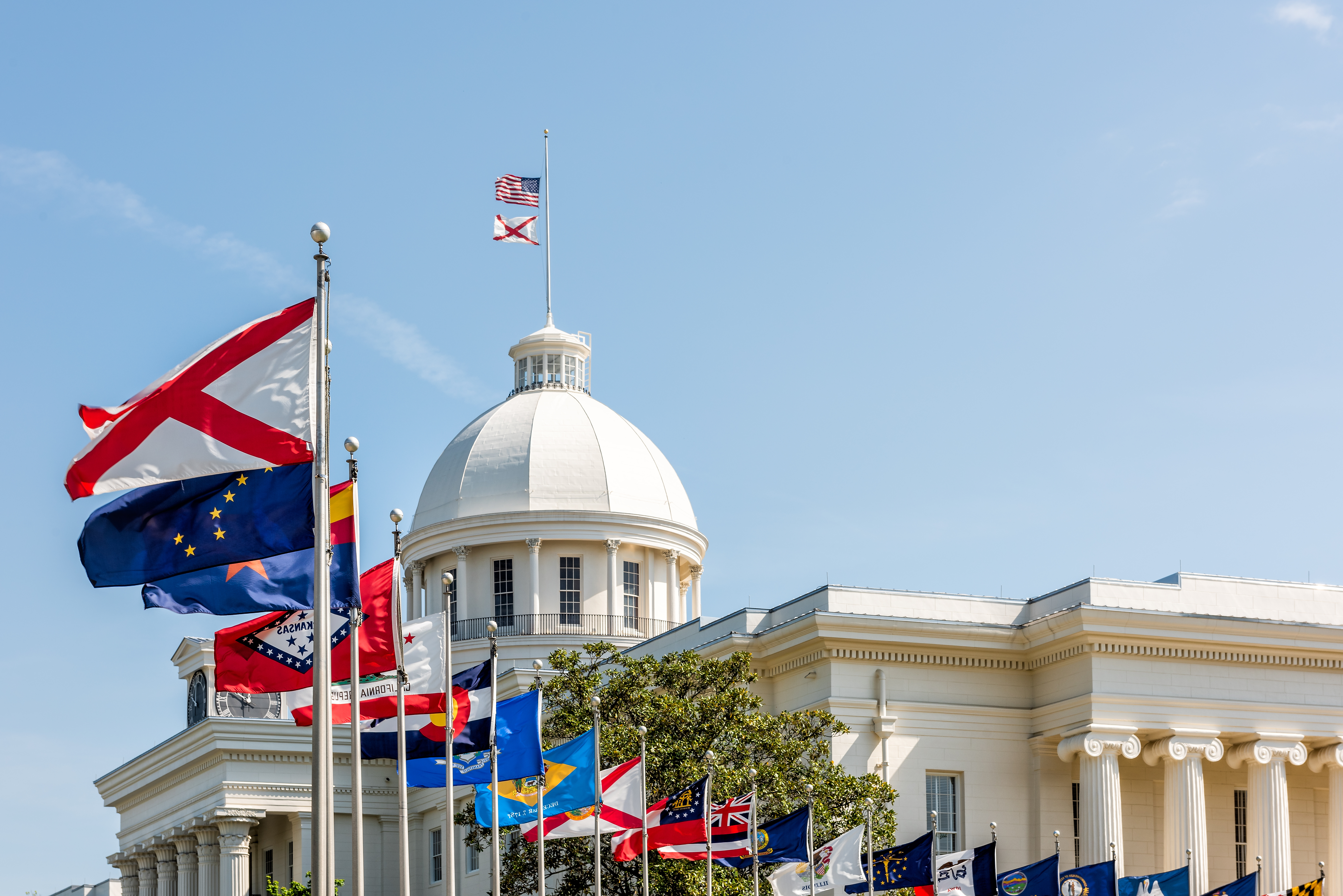 Alabama State Capitol building with state and American flags